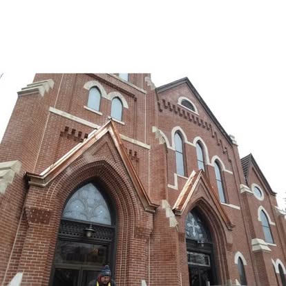 Historic brick church with copper gable peak accents