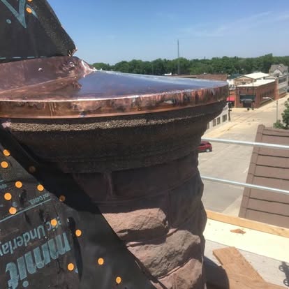Copper dome cap on a stone column with city view