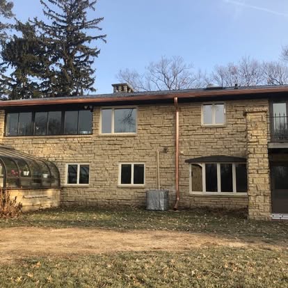 Stone home with copper fascia and gutter trim